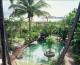 Pool surrounded by lush tropical garden 
 - Hotel Tropiq